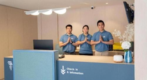 three men standing behind a counter with their arms crossed at 777Bliss Hometel in Nakhon Phanom
