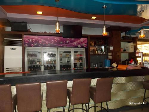 a bar with a bunch of chairs in a room at MO2 Westown Hotel San Juan in Bacolod