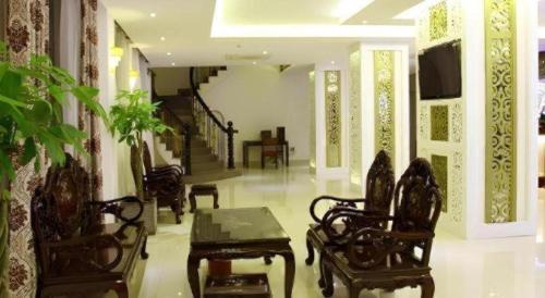 a living room with chairs and a table and a staircase at Rain Bow Hotel in Ho Chi Minh City