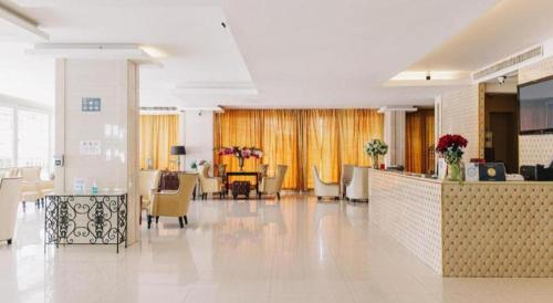 a lobby with chairs and a reception desk in a building at Aramis Hotel in Nakhon Sawan