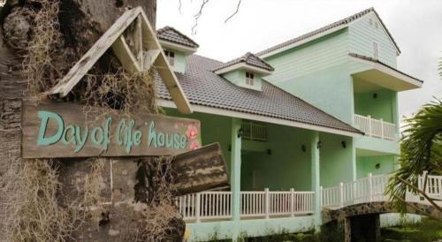 a green house with a sign in front of it at Charisma Resort in Ratchaburi