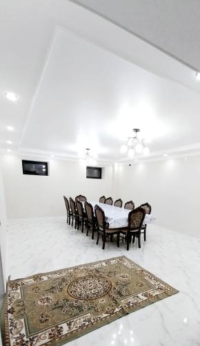 a white room with a table and chairs and a rug at Hamza Guest House 