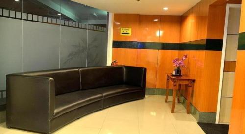 a leather couch in a room with a table at Hotel Sogo Tarlac in Tarlac