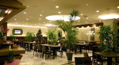 a restaurant with tables and chairs and plants at Metro Tourist Hotel Cheonan in Cheonan