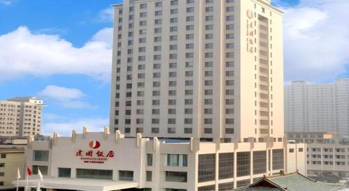 a large white building with a sign on it at Yuncheng Jianguo Hotel in Yuncheng