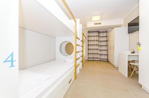 a room with white walls and a staircase with a mirror at Hostel Dvor in Split
