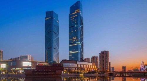 two tall skyscrapers in a city at dusk at Dongwu New Century Grand Hotel Huzhou in Huzhou