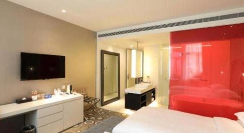 a bedroom with a red tub and a bathroom with a sink at Jinjiang Metropolo Hotel Classiq Shanghai Off Bund in Shanghai