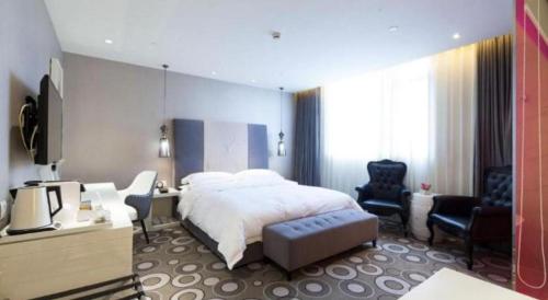 a bedroom with a bed and a tv and chairs at Jinjiang Metropolo Hotel Classiq Shanghai Off Bund in Shanghai