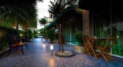 a patio with chairs and a table and a tree at The Loom Rangsit in Pathum Thani