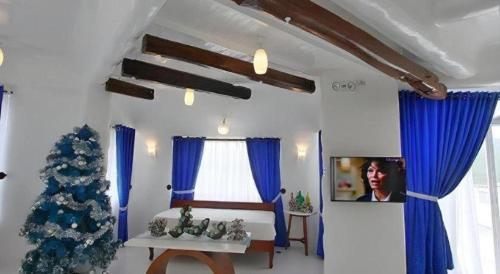 a living room with a christmas tree and blue curtains at Vitalis White Sands in Vigan