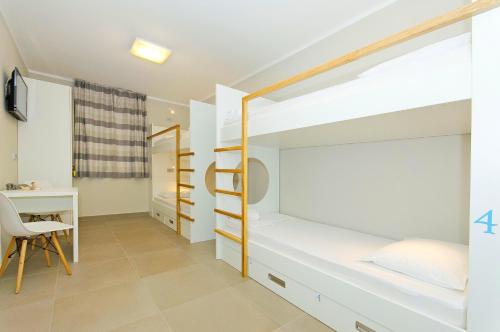 a bedroom with two bunk beds and a desk at Hostel Dvor in Split