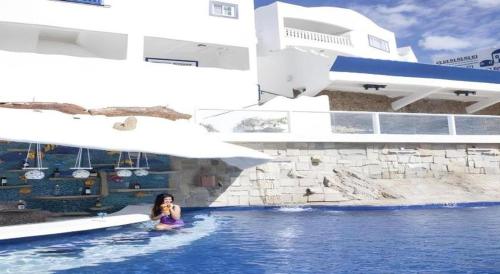 a woman sitting in a pool at a resort at Vitalis White Sands in Vigan