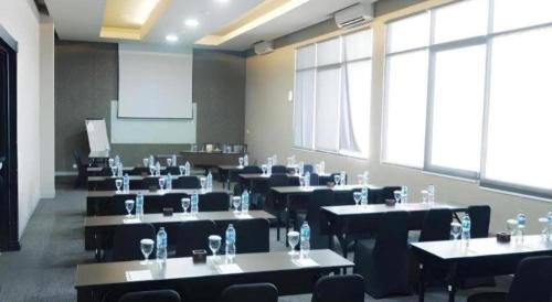 a classroom with tables and chairs in a room at Grage Hotel Cirebon in Cirebon