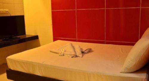 a hotel room with a bed with a towel on it at One Serenata Hotel General Trias in Silang