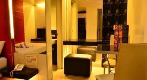 a room with a bedroom with a bed and a mirror at One Serenata Hotel General Trias in Silang