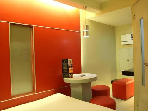 a small bathroom with a sink and a red wall at One Serenata Hotel General Trias in Silang