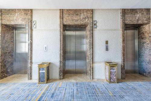 a lobby with three elevators in a building at Yanji Yanbian International Hotel in Yanji