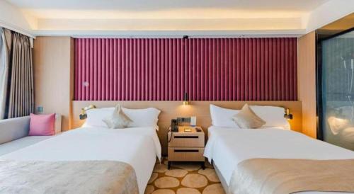 two beds in a hotel room with red walls at Yanji Yanbian International Hotel in Yanji