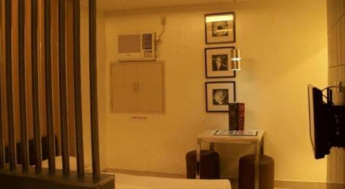 a living room with a table and a microwave at One Serenata Hotel General Trias in Silang