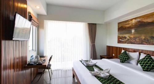 a hotel room with two beds and a window at Hadi Poetra Hotel in Kuta