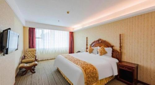 a hotel room with a bed and a television at Yanji Yanbian International Hotel in Yanji