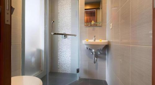 a bathroom with a sink and a shower and a toilet at Hadi Poetra Hotel in Kuta