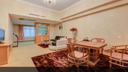 a living room with a table and a couch at Zhuhai Dehan Hotel in Zhuhai