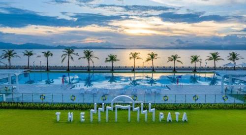 a large swimming pool with palm trees in the background at Ocean Spring Metropark Hotel Zhuhai in Zhuhai