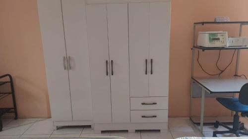Armario blanco en una habitación con escritorio en Quarto para o Círio de Nazaré a 2 quadras da Basílica!, en Belém