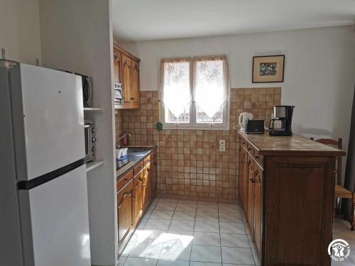 a kitchen with a white refrigerator and a window at Grenache rdc in Fosse