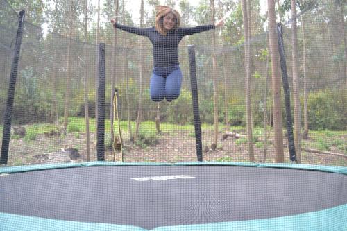 a woman jumping in the air on a trampoline at Hotel Medina Del Lago in Otavalo