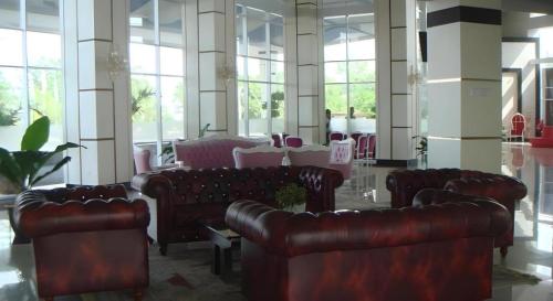 a large room with leather couches and tables and windows at CK Tanjungpinang Hotel and Convention Centre in Tanjung Pinang 