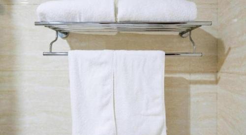a towel rack with three towels on it in a bathroom at GreenTree Inn Beijing East Yizhuang District Second Kechuang Street Express Hotel in Beijing