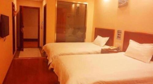 a hotel room with two beds and a phone at GreenTree Inn Beijing East Yizhuang District Second Kechuang Street Express Hotel in Beijing
