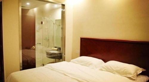 a bedroom with a bed and a glass shower at GreenTree Inn Beijing East Yizhuang District Second Kechuang Street Express Hotel in Beijing