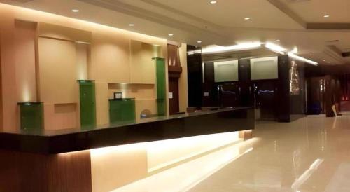 a lobby with a long counter in a building at Alvarez Hotel in Buriram