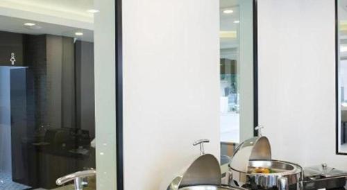 a bathroom with two sinks and two mirrors at The Circle Hotel in Buriram