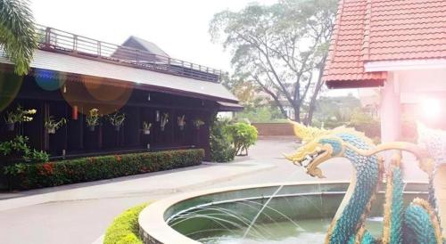 a fountain with a dragon in front of a building at NH Elegant Hotel in Sakon Nakhon