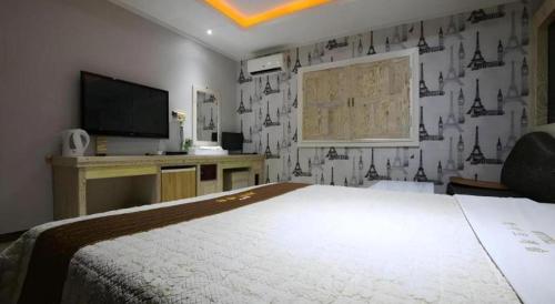 a bedroom with a large bed and a television at Hotel Primo Daejeon in Daejeon