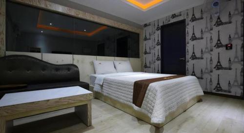 a bedroom with a large bed and a couch at Hotel Primo Daejeon in Daejeon