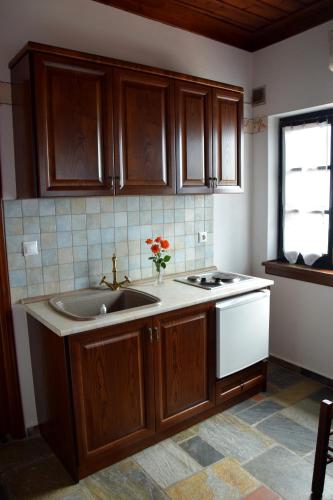 a kitchen with wooden cabinets and a sink and a window at Vera's Traditional House in Zagora