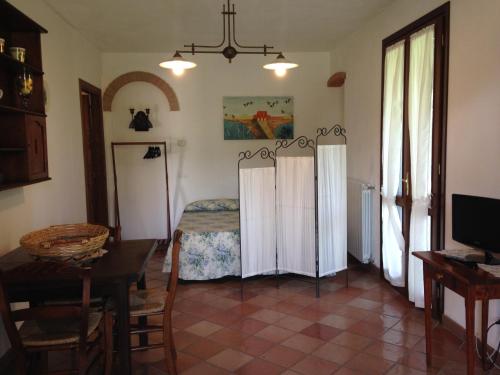una sala de estar con una cama y una mesa en Il Vivaio, en Castiglione della Pescaia