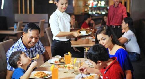 a group of people sitting at a table eating food at Hotel Estrella in Tacloban