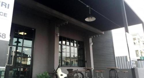 a building with tables and chairs in front of it at Rider bedroom hostel & cafe in Hua Hin