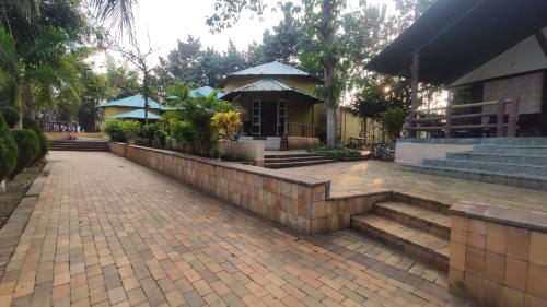 a house with a brick walkway and a building with stairs at Gopala Grand in Jabalpur