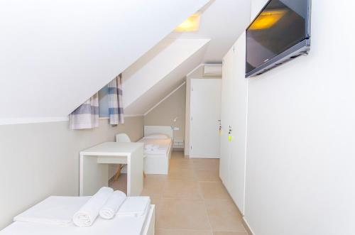 a room with a bed and a desk and a tv at Hostel Dvor in Split