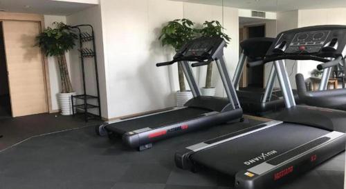 a gym with two exercise bikes and a treadmill at New Century Kylie Hotel Ningbo in Ningbo