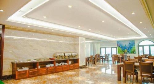 a restaurant with tables and chairs in a room at Bacninh Charming Hotel in Bắc Ninh