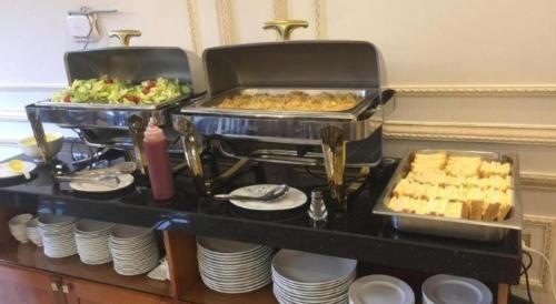a buffet with food on a table with plates at Bacninh Charming Hotel in Bắc Ninh